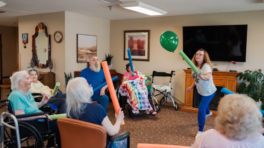 A group of elderly people playing a game together, both long term care and short term care residents