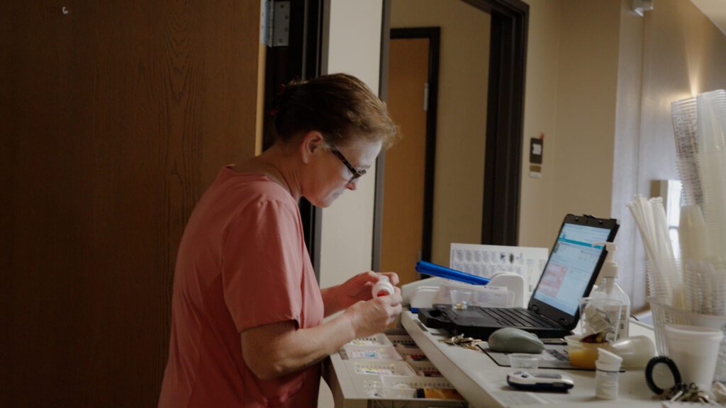 A nurse works on the computer at a skilled nursing facility