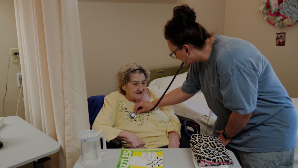 a nurse who specializes in skilled nursing assists a woman at a nursing home