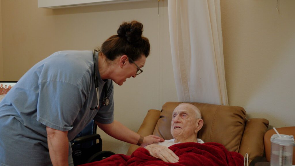 A man and nurse are talking at a dementia care facility