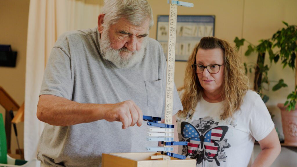 A man and nurse are working through a physical therapy session at a short term care facility